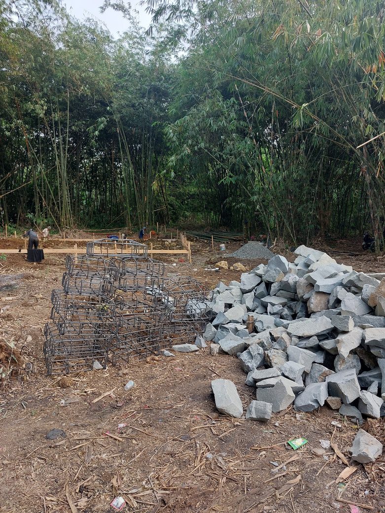 Material besi tulangan dan batu pondasi siap dipasang